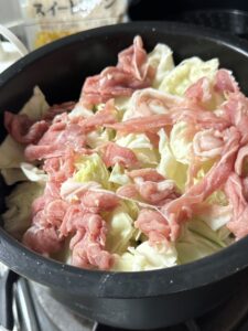 ホットクックの内鍋に豚肉とキャベツなどの具材が並べられた調理前の状態