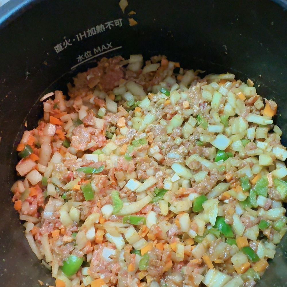 ホットクックにセットされたドライカレーの材料(ひき肉、野菜、調味料)