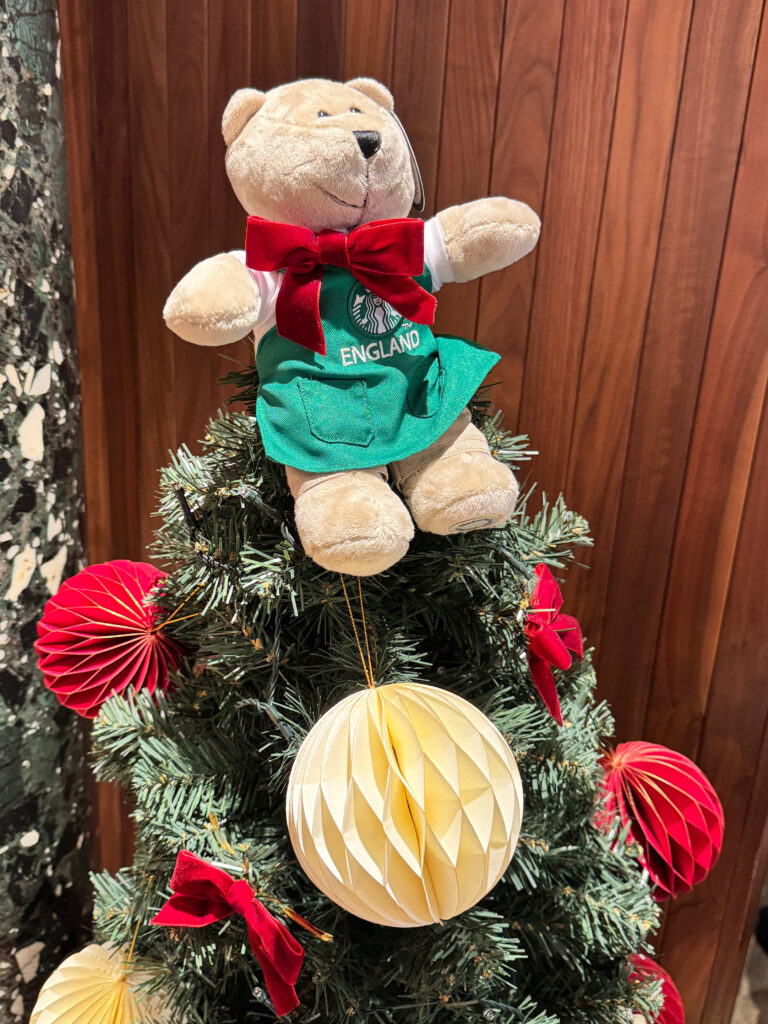 ロンドンのスターバックス店内に飾られていたクリスマスツリーと、エプロン姿のクマのぬいぐるみ