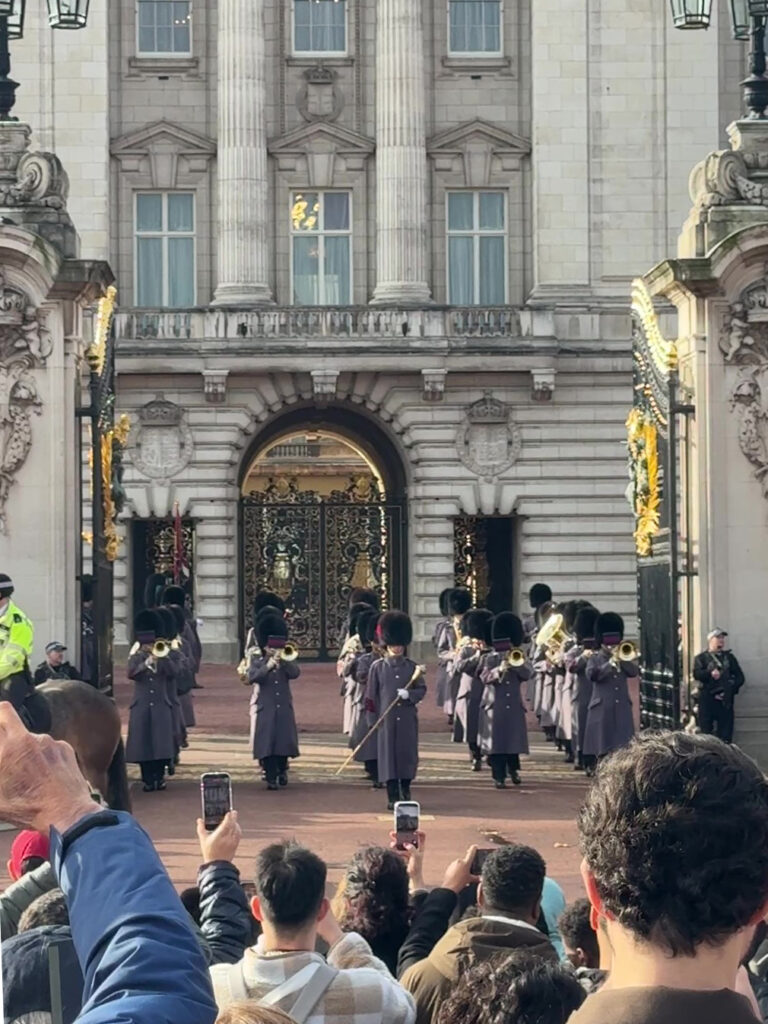 バッキンガム宮殿の門から楽器を演奏して出発する衛兵たち