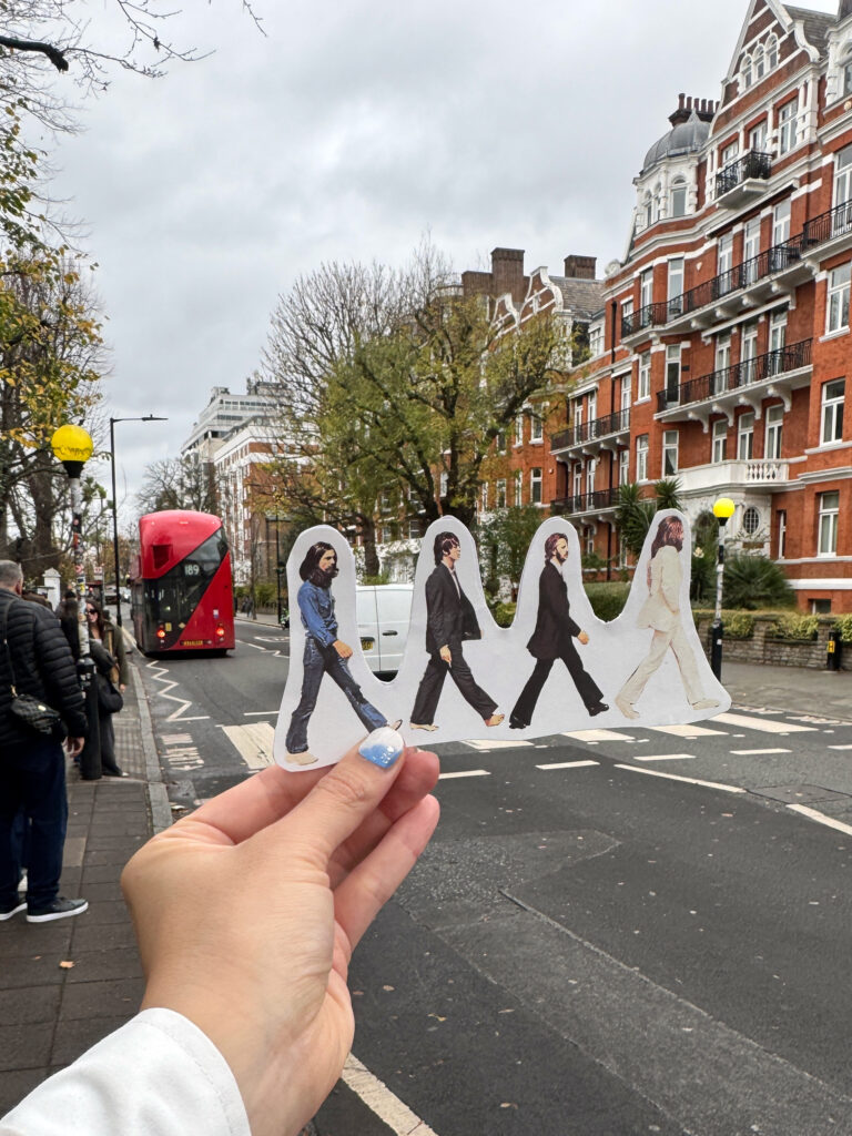 ビートルズのメンバーが横断歩道を渡る姿を模したフォトプロップスと、アビイ・ロードの実際の横断歩道を一緒に撮影した写真