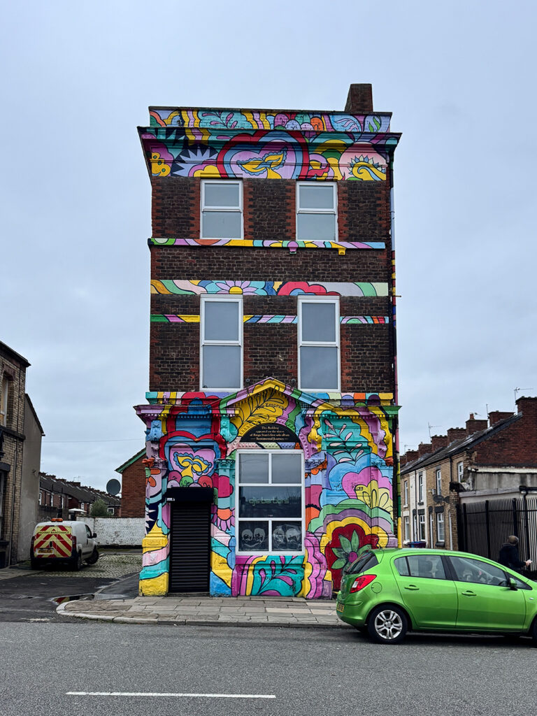 リンゴ・スターが描かれたピンクの家正面