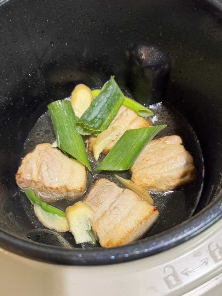 シェフドラムの内なべに焼き色をつけた豚バラ肉・長ねぎ・生姜を入れた状態