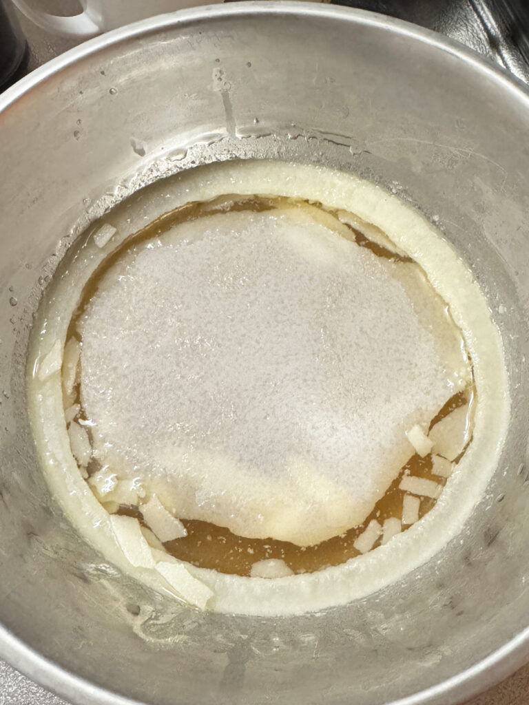 ステンレスボウルの煮汁を冷まして固まった豚肉の脂